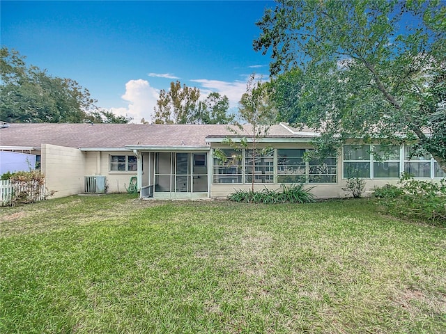 back of house featuring a yard, a sunroom, and central AC unit