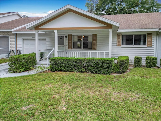 ranch-style house featuring covered porch, a front yard, and a garage