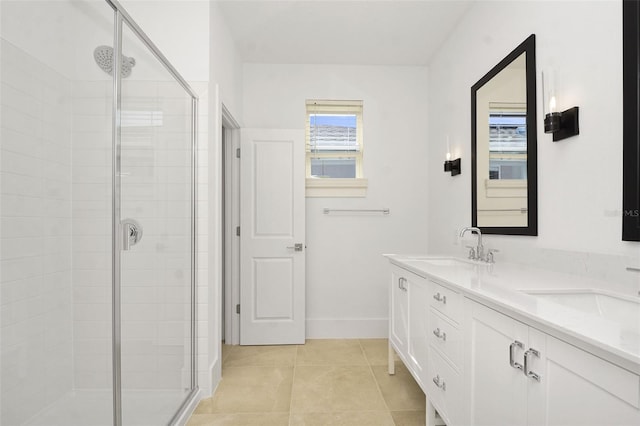 bathroom with a shower with door, vanity, and tile patterned floors