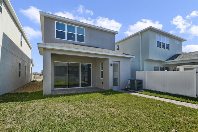 rear view of property with a lawn and central air condition unit