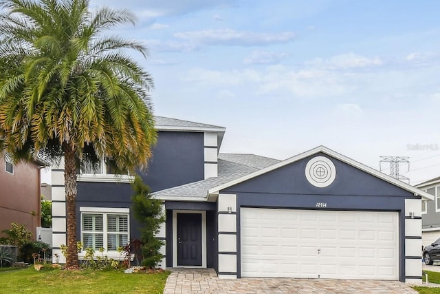 view of front of property featuring a front yard and a garage