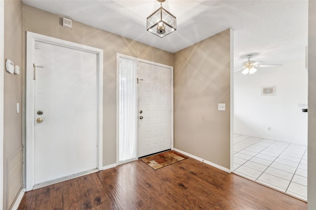 entryway featuring ceiling fan, hardwood / wood-style flooring, and a textured ceiling