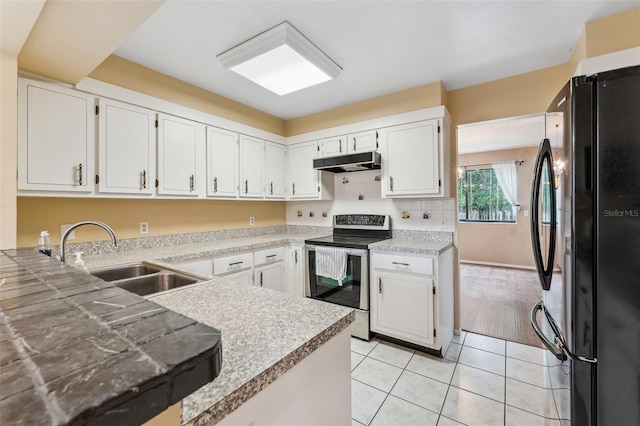 kitchen featuring white cabinetry, sink, black refrigerator, and stainless steel electric range oven