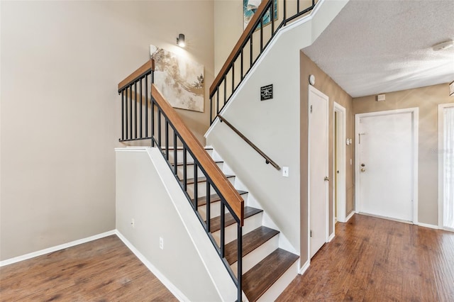 stairs featuring a textured ceiling and wood-type flooring