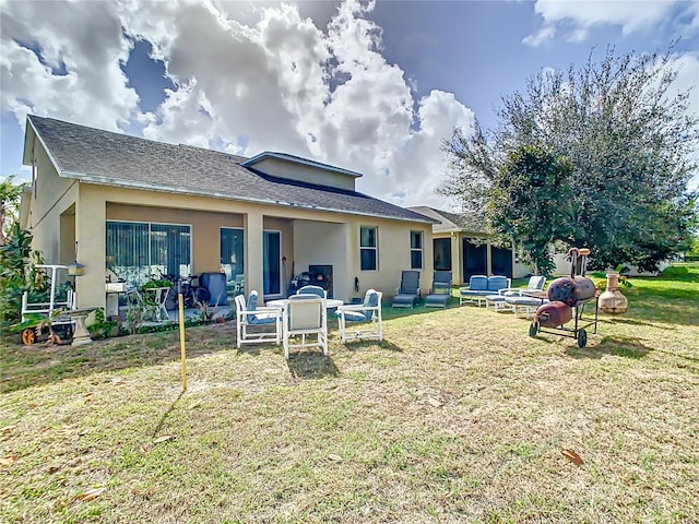 rear view of house with a patio, a lawn, and a fire pit