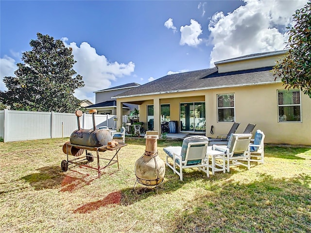 back of property featuring a patio area and a lawn