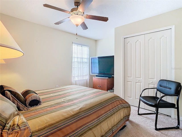 bedroom featuring light colored carpet, a closet, and ceiling fan