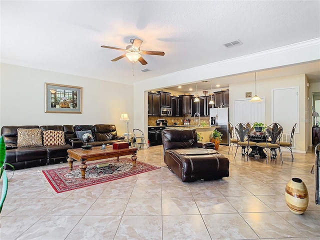 living room featuring sink, ceiling fan, a textured ceiling, and light tile patterned flooring