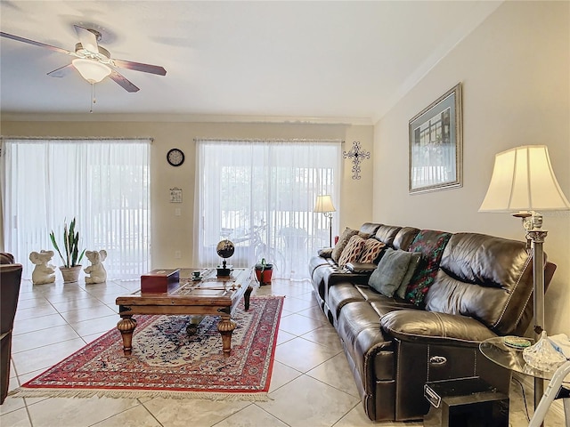 tiled living room with ceiling fan and ornamental molding