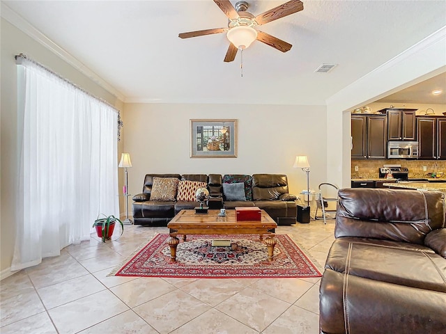 living room featuring ornamental molding, light tile patterned floors, and ceiling fan