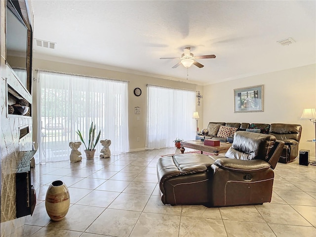 tiled living room with ornamental molding, a fireplace, and ceiling fan