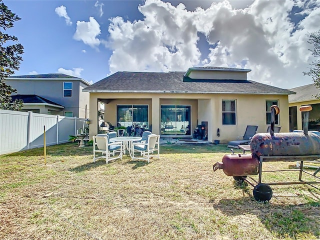 back of house with a patio area and a lawn