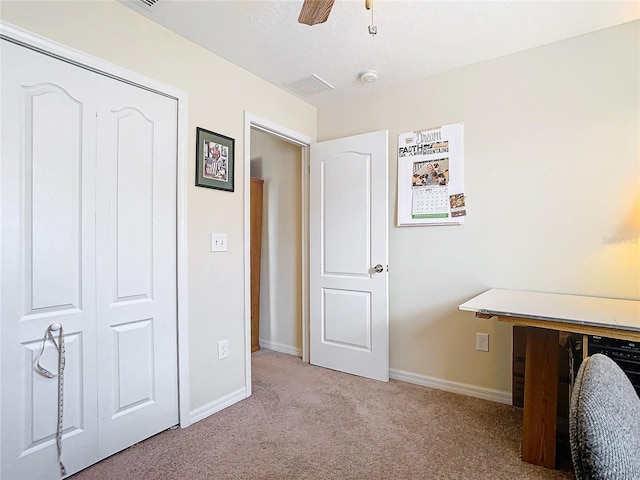 unfurnished bedroom featuring light carpet, a closet, and ceiling fan