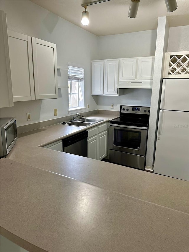 kitchen with appliances with stainless steel finishes, white cabinets, sink, and rail lighting