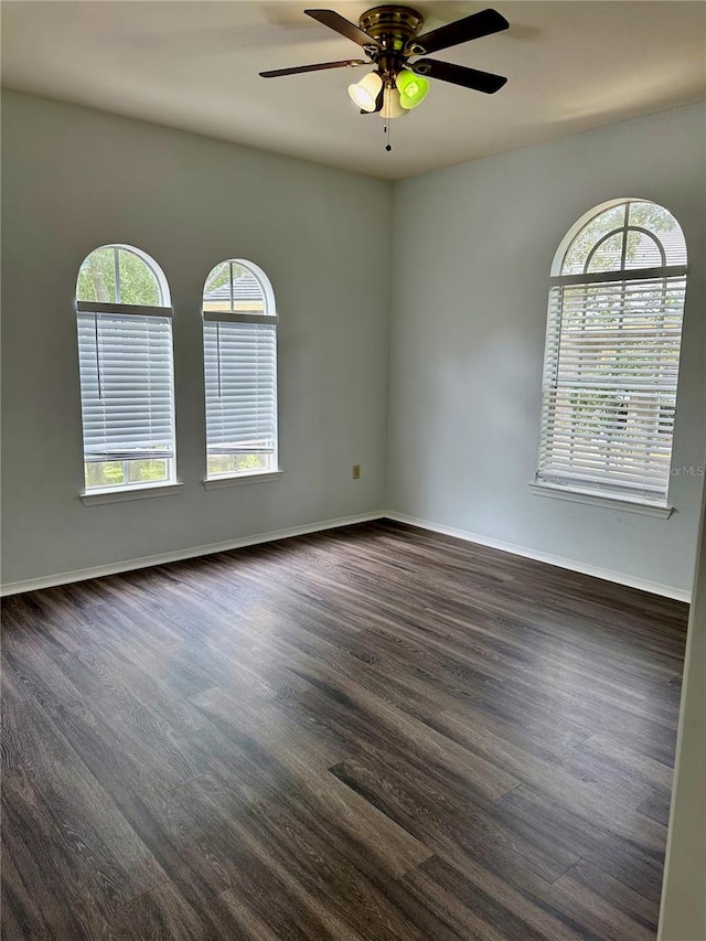 unfurnished room with ceiling fan, a healthy amount of sunlight, and dark hardwood / wood-style flooring