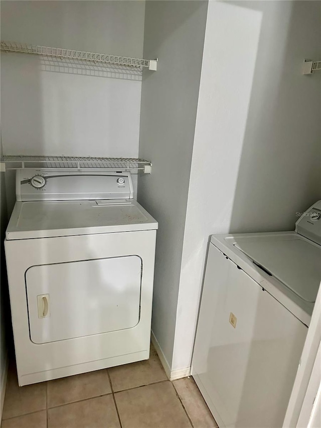 laundry area featuring light tile patterned flooring and washing machine and clothes dryer