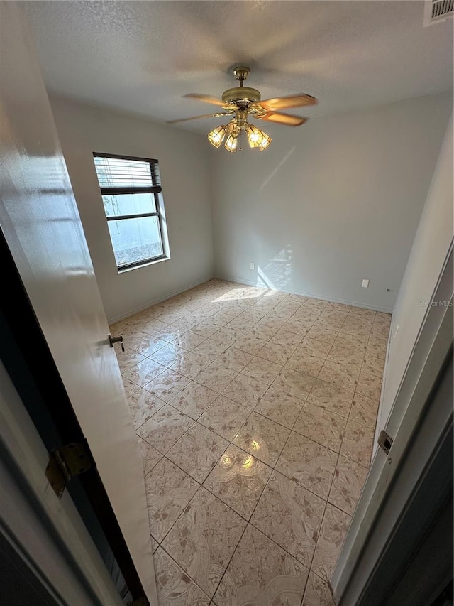 spare room with ceiling fan and a textured ceiling