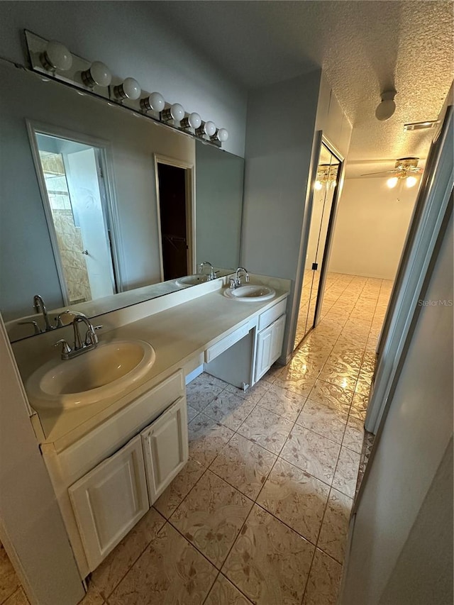 bathroom featuring vanity, a textured ceiling, tile patterned floors, and ceiling fan