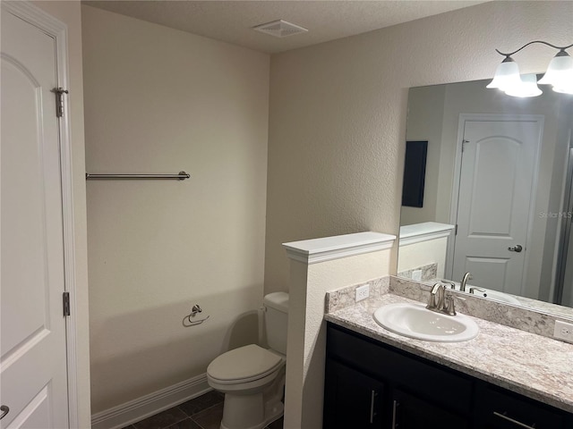 bathroom featuring tile patterned flooring, a textured ceiling, vanity, and toilet