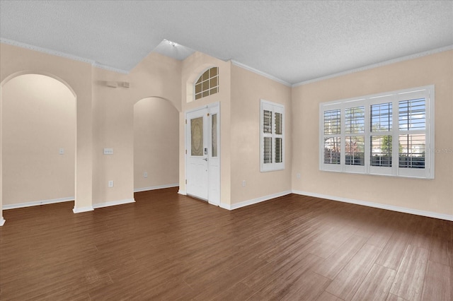 spare room featuring a textured ceiling, dark hardwood / wood-style flooring, and ornamental molding