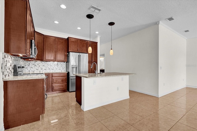 kitchen featuring an island with sink, a textured ceiling, stainless steel appliances, decorative light fixtures, and light stone counters