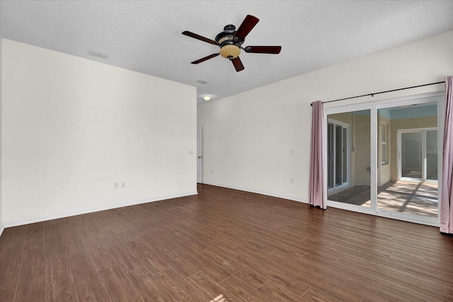 empty room with a textured ceiling, dark wood-type flooring, and ceiling fan