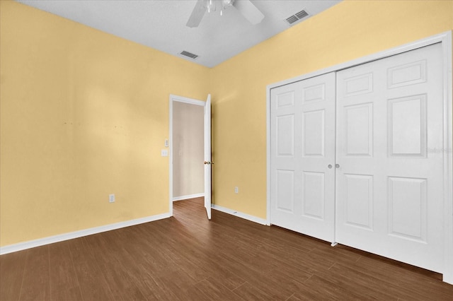 unfurnished bedroom featuring dark hardwood / wood-style floors, a closet, and ceiling fan