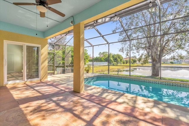 view of swimming pool featuring a patio area, ceiling fan, a water view, and a lanai