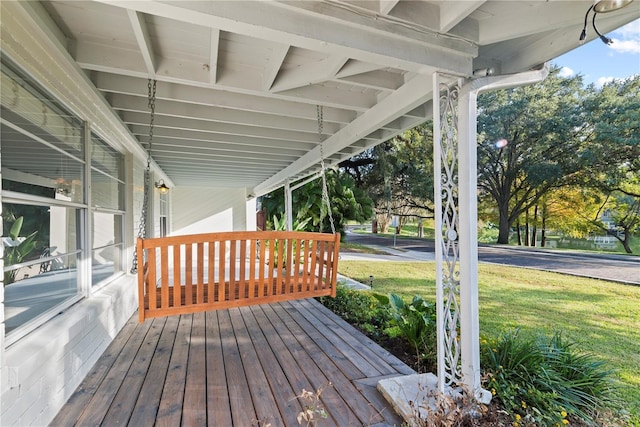 deck with covered porch and a yard