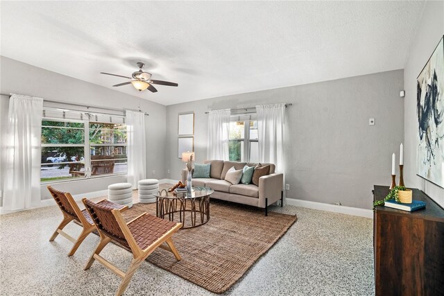 living room with vaulted ceiling, ceiling fan, and a textured ceiling