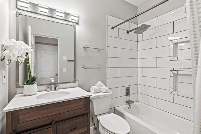 full bathroom featuring vanity, tiled shower / bath, and toilet