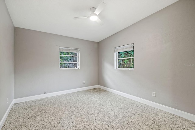 unfurnished room with a wealth of natural light, ceiling fan, and vaulted ceiling