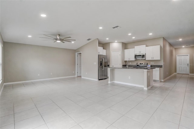 kitchen featuring a center island with sink, white cabinetry, light tile patterned floors, appliances with stainless steel finishes, and ceiling fan