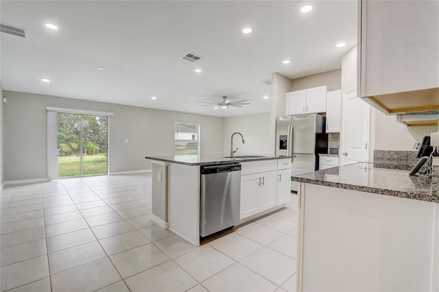 kitchen featuring white cabinets, a center island with sink, stainless steel appliances, and sink