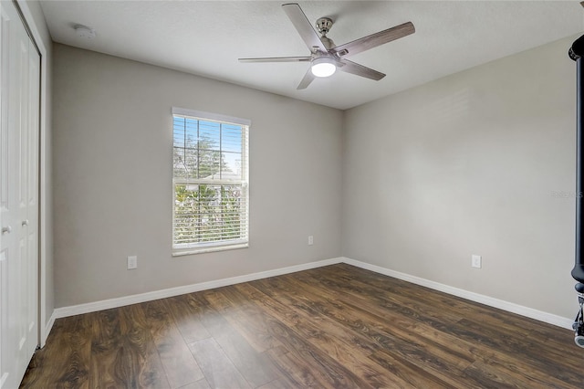 unfurnished room featuring dark wood-type flooring and ceiling fan