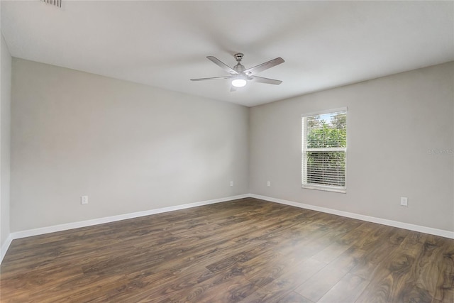 unfurnished room featuring dark wood-type flooring and ceiling fan