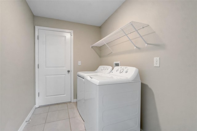 washroom featuring washer and clothes dryer and light tile patterned floors