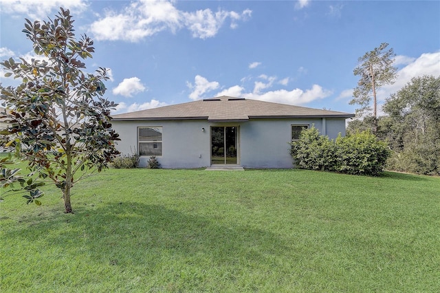 rear view of house featuring a lawn