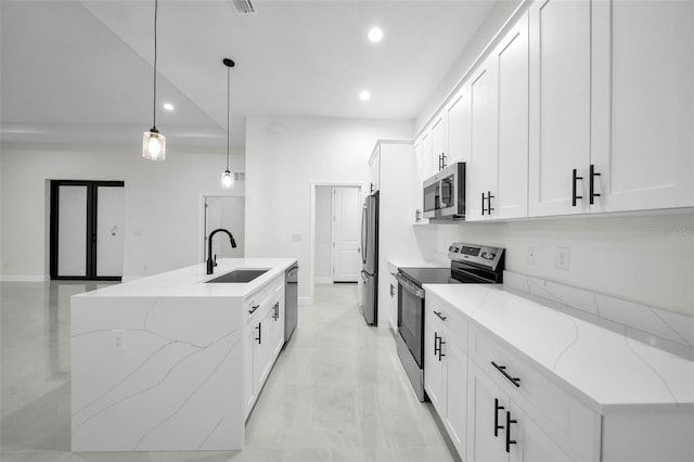 kitchen featuring appliances with stainless steel finishes, decorative light fixtures, white cabinetry, sink, and light stone countertops