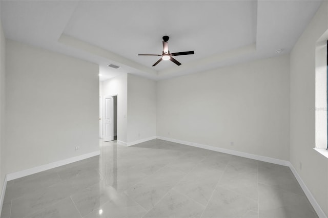 unfurnished room featuring a tray ceiling and ceiling fan