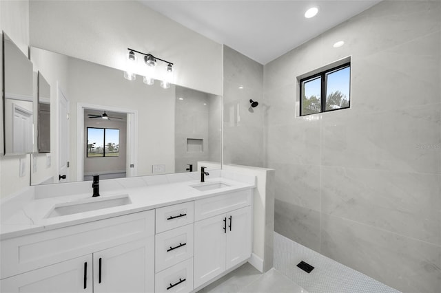 bathroom featuring tile patterned floors, tiled shower, a healthy amount of sunlight, and vanity