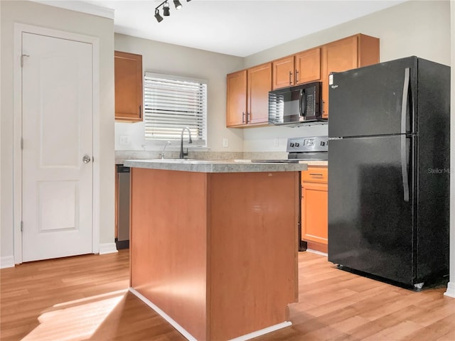 kitchen featuring light hardwood / wood-style floors, a center island, black appliances, and sink