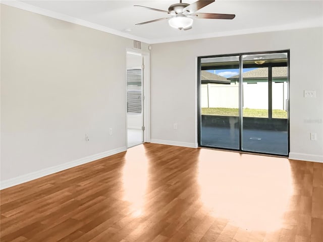 empty room with ornamental molding, wood-type flooring, and ceiling fan