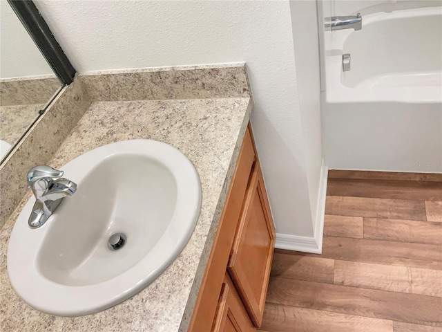 bathroom with vanity, a textured ceiling, and hardwood / wood-style floors