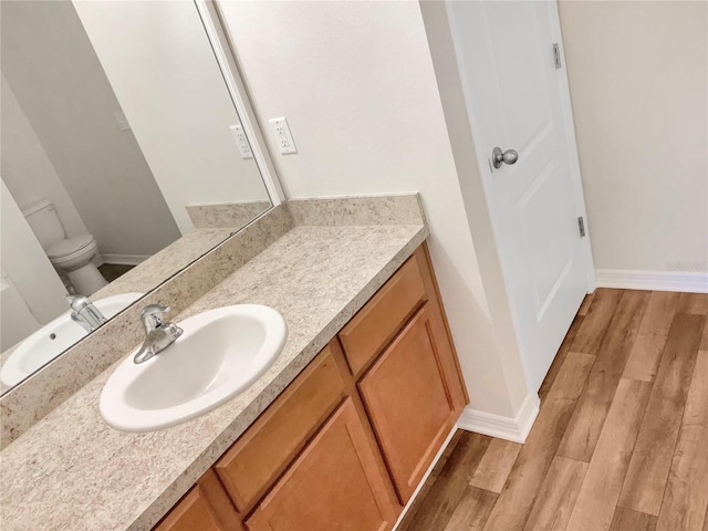 bathroom with vanity, toilet, and wood-type flooring