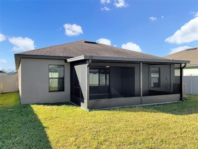 rear view of property featuring a yard and a sunroom