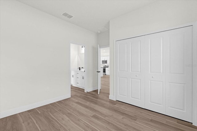 unfurnished bedroom featuring light hardwood / wood-style floors and a closet