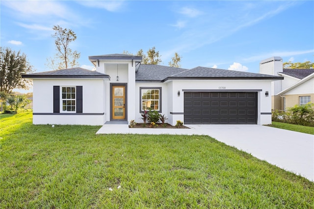 prairie-style house featuring a front yard and a garage