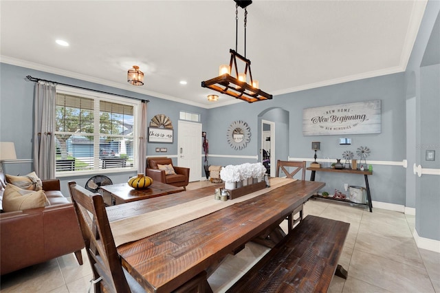 dining space featuring a notable chandelier, ornamental molding, and light tile patterned floors