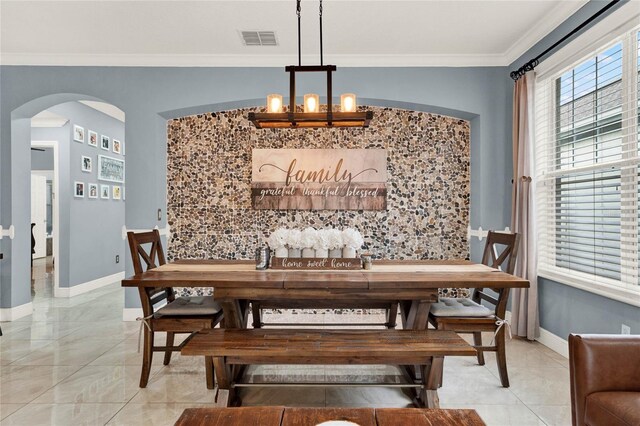 dining area with ornamental molding and an inviting chandelier